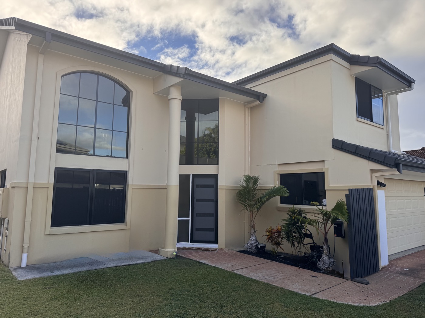 House front before repaint — faded cream render